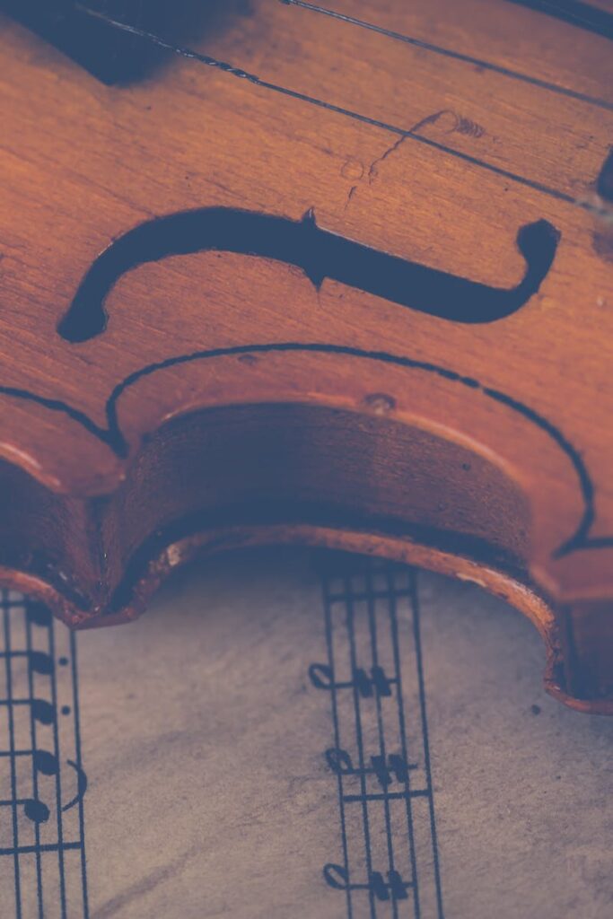 Artistic close-up of a violin on sheet music, highlighting musical elegance.